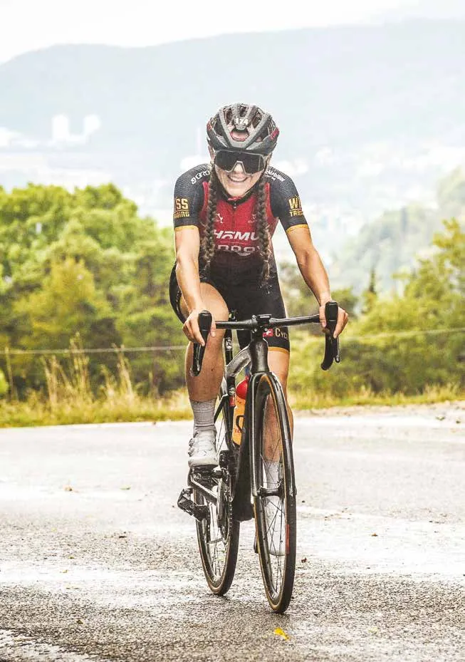 Alina Myłka lächelnd an einem Anstieg im Clubtrikot